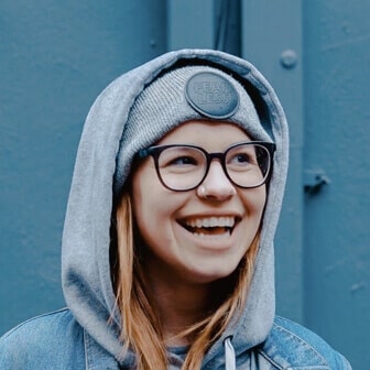 Laughing young woman in glasses and hoodie